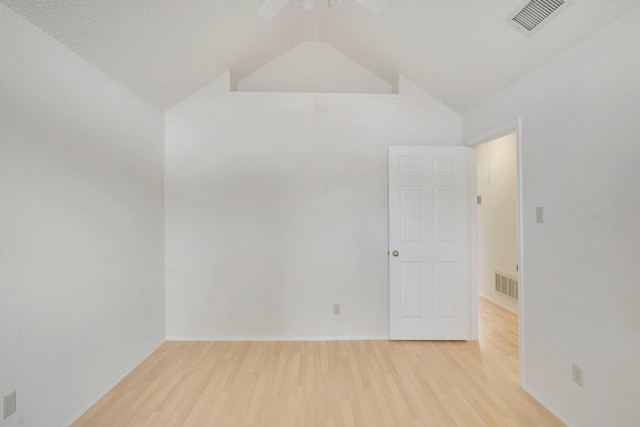 empty room featuring wood-type flooring, vaulted ceiling, and ceiling fan