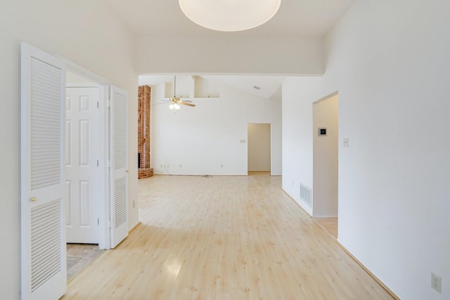 corridor with hardwood / wood-style floors and vaulted ceiling