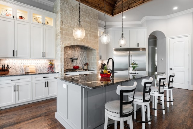 kitchen with white cabinetry, a kitchen island with sink, tasteful backsplash, and stainless steel appliances