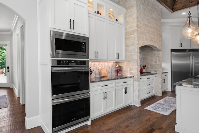 kitchen with pendant lighting, dark stone countertops, white cabinets, and decorative backsplash