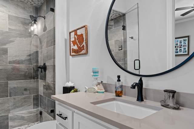 bathroom with toilet, crown molding, vanity, a shower with door, and ceiling fan