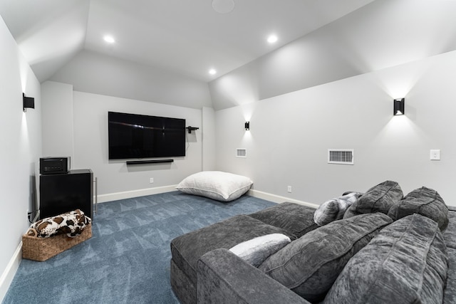 carpeted home theater room with vaulted ceiling