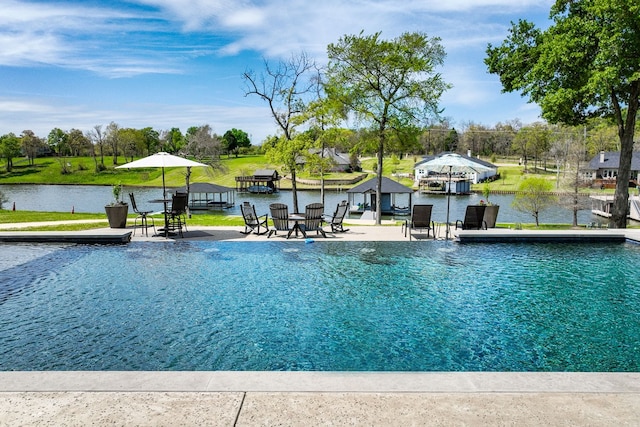 view of swimming pool featuring a water view and a patio