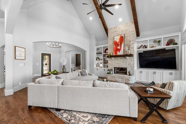 living room with beamed ceiling, a fireplace, high vaulted ceiling, and built in features