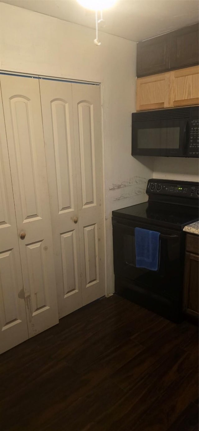 kitchen featuring dark wood-type flooring and black appliances