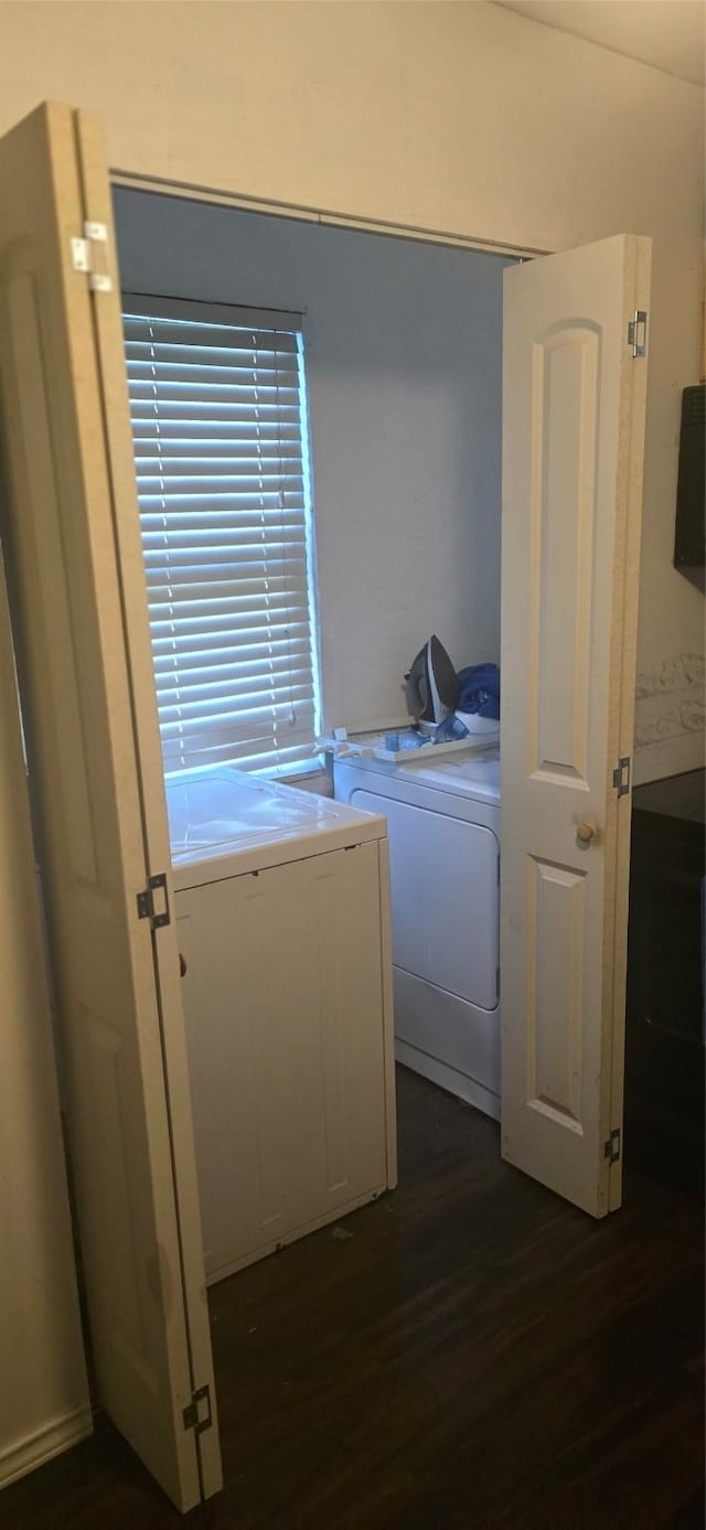 laundry area with washing machine and clothes dryer and dark hardwood / wood-style floors