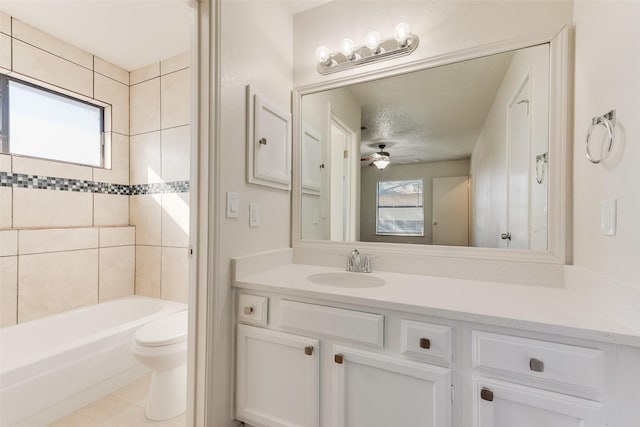 full bathroom with tiled shower / bath combo, vanity, a healthy amount of sunlight, and toilet