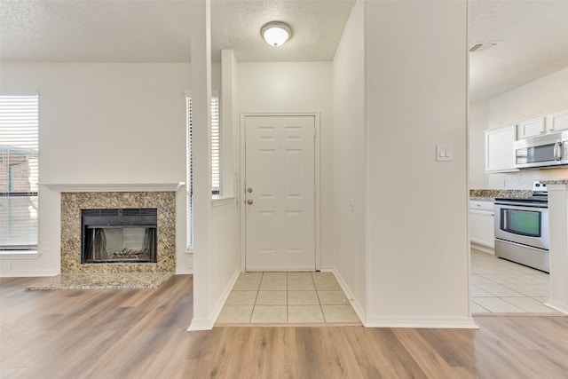 tiled foyer with a premium fireplace and a textured ceiling