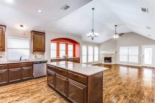 kitchen featuring a sink, a kitchen island, visible vents, light countertops, and dishwasher