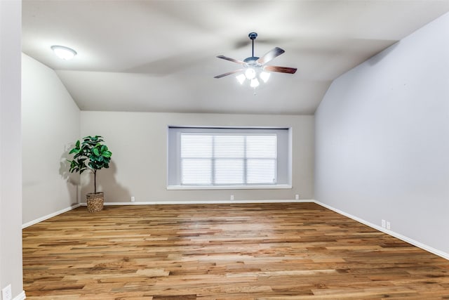 spare room featuring light wood-type flooring, lofted ceiling, and ceiling fan