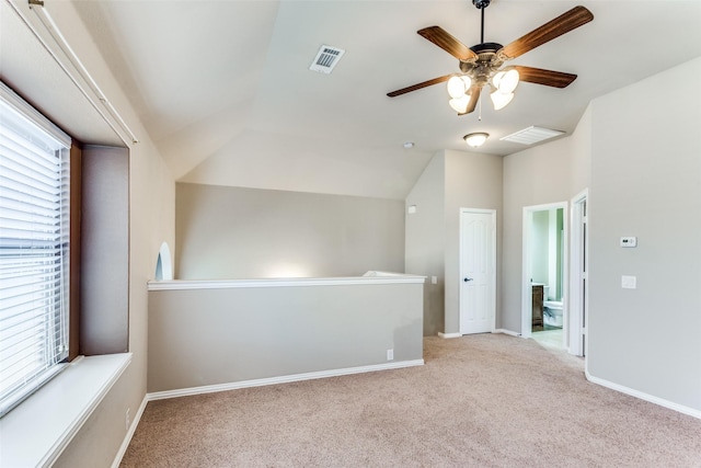 additional living space featuring visible vents, light carpet, vaulted ceiling, ceiling fan, and baseboards