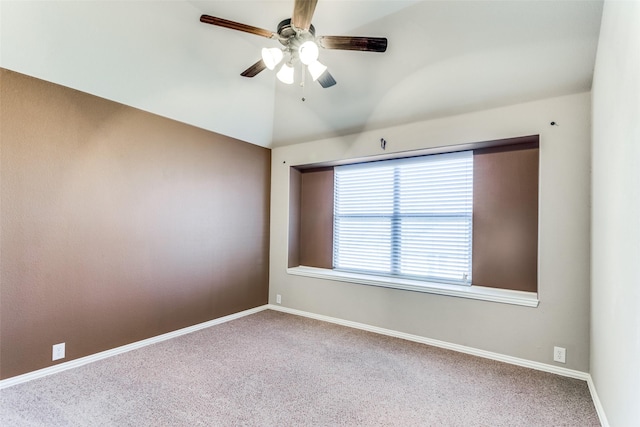 carpeted empty room featuring lofted ceiling, ceiling fan, and baseboards