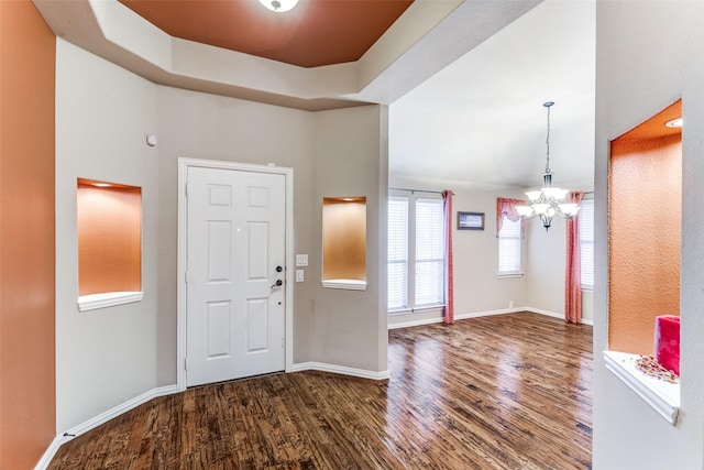 foyer featuring dark wood-type flooring and a chandelier