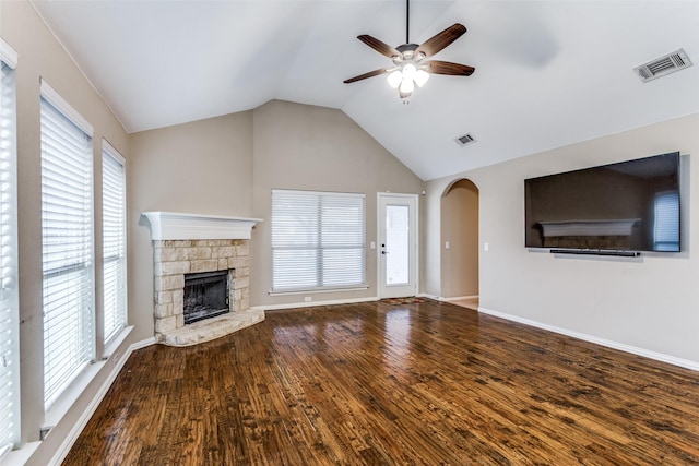 unfurnished living room featuring lofted ceiling, visible vents, a fireplace, and wood finished floors