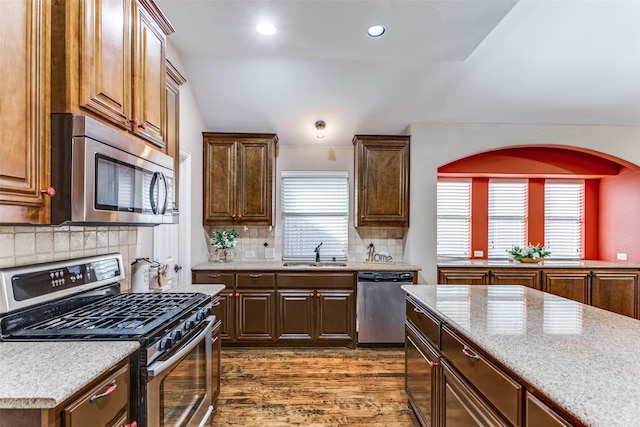 kitchen with recessed lighting, a sink, appliances with stainless steel finishes, tasteful backsplash, and dark wood finished floors