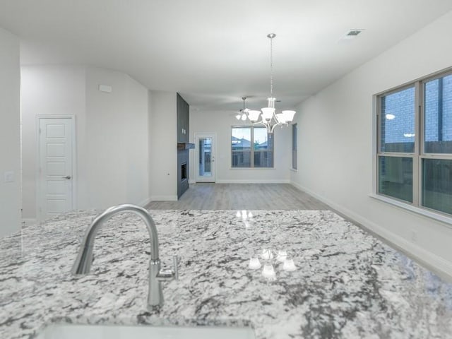 interior space featuring sink, a chandelier, and light wood-type flooring