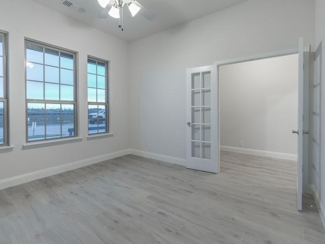 spare room with french doors, ceiling fan, and light wood-type flooring