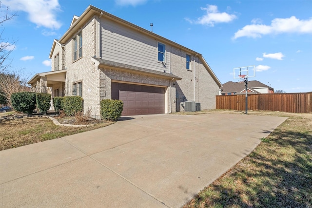 view of side of home with a garage and central AC