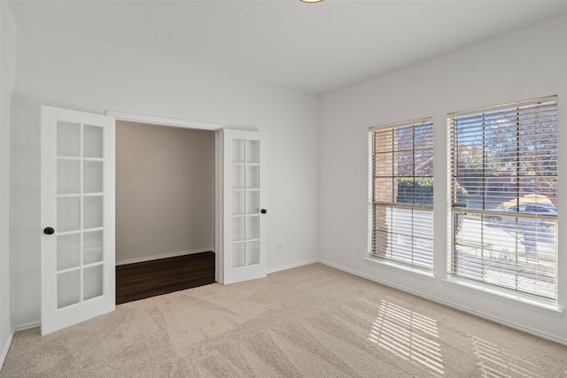 spare room with carpet floors and french doors