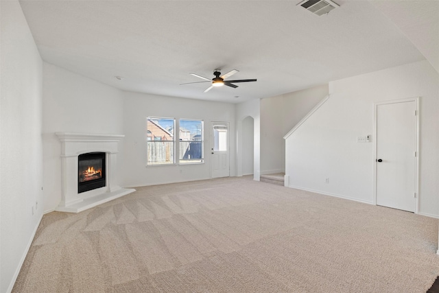 unfurnished living room featuring light carpet and ceiling fan