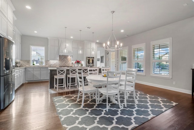 dining room with dark wood-type flooring and a chandelier