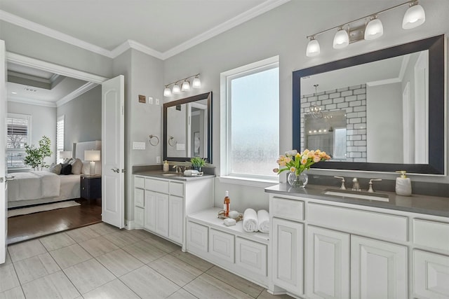 bathroom featuring a tile shower, ornamental molding, two vanities, and a sink