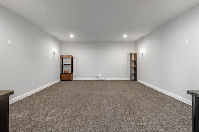 empty room featuring visible vents, recessed lighting, baseboards, and dark carpet