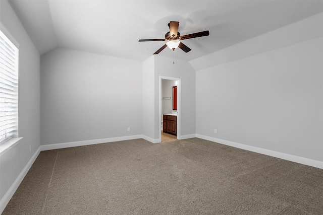 spare room with light colored carpet, baseboards, a ceiling fan, and vaulted ceiling