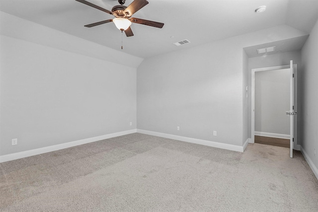 empty room featuring visible vents, baseboards, ceiling fan, vaulted ceiling, and carpet flooring