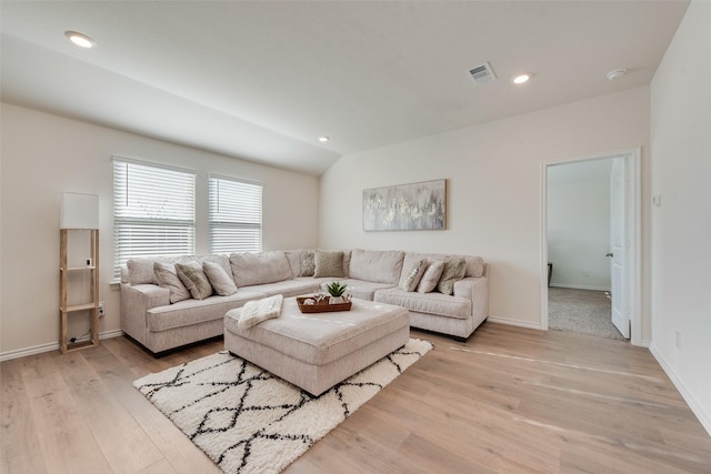 living room featuring vaulted ceiling and light wood-type flooring