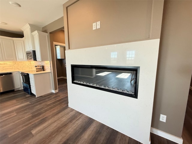 kitchen featuring stainless steel appliances, tasteful backsplash, white cabinets, and dark hardwood / wood-style flooring