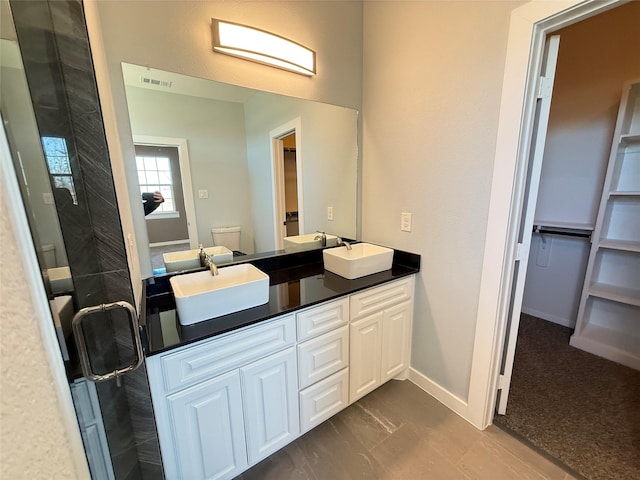 bathroom featuring vanity, tile patterned flooring, toilet, and walk in shower