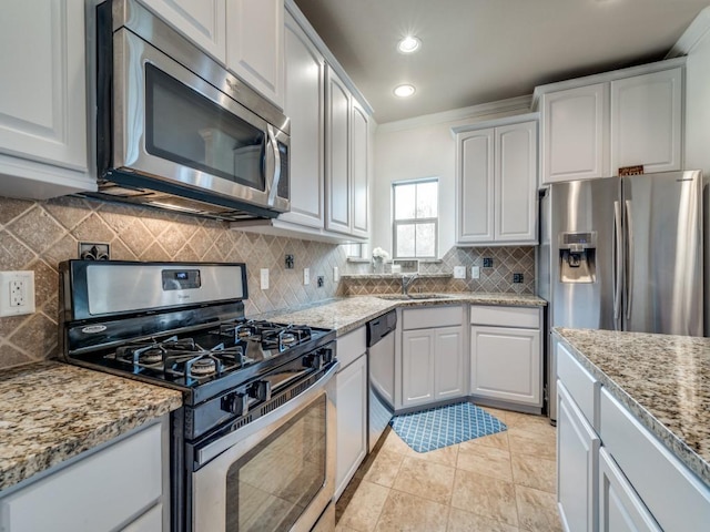 kitchen featuring light stone countertops, appliances with stainless steel finishes, sink, and white cabinets