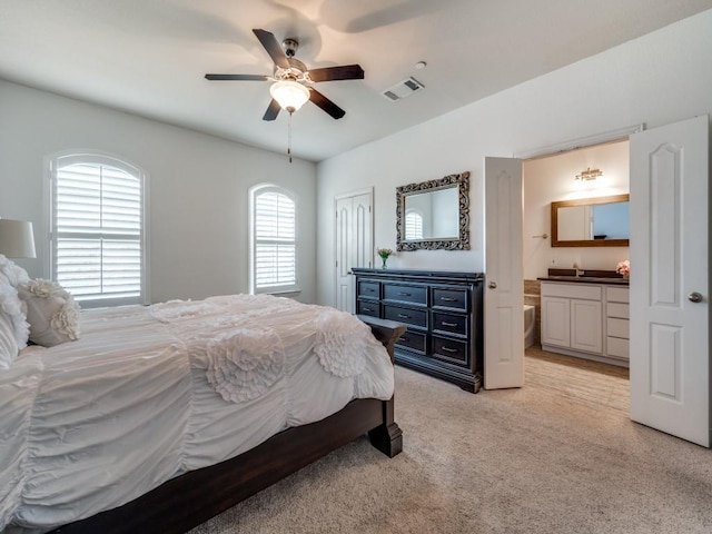 carpeted bedroom featuring ceiling fan and ensuite bathroom