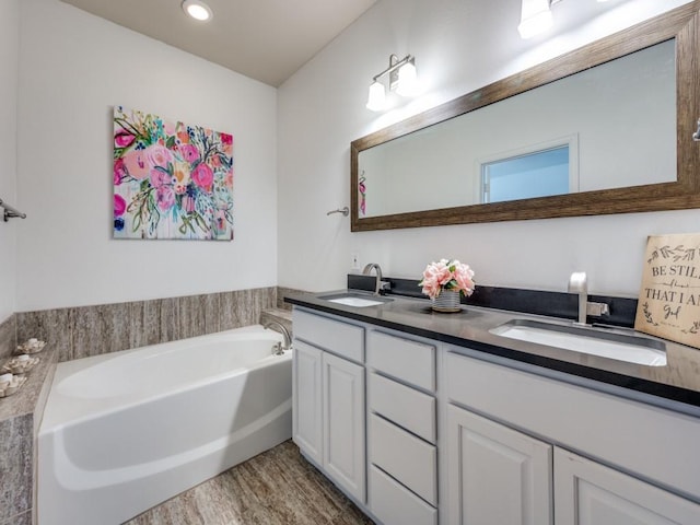 bathroom featuring vanity, a bath, and wood-type flooring