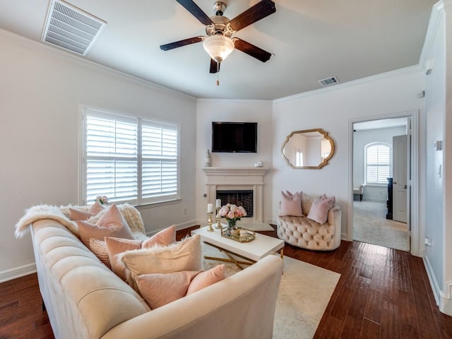 living room with crown molding, dark hardwood / wood-style floors, and ceiling fan