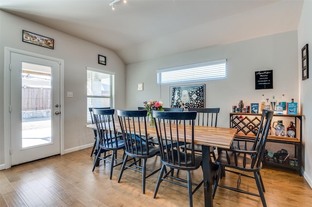 dining room featuring lofted ceiling and light wood-type flooring