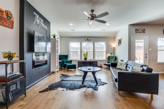 living room with ceiling fan and light wood-type flooring