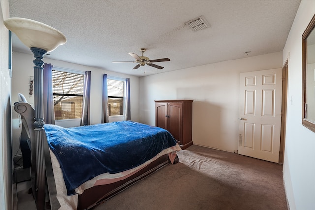 bedroom featuring ceiling fan, carpet floors, and a textured ceiling