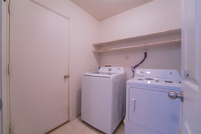 laundry room featuring separate washer and dryer and a textured ceiling