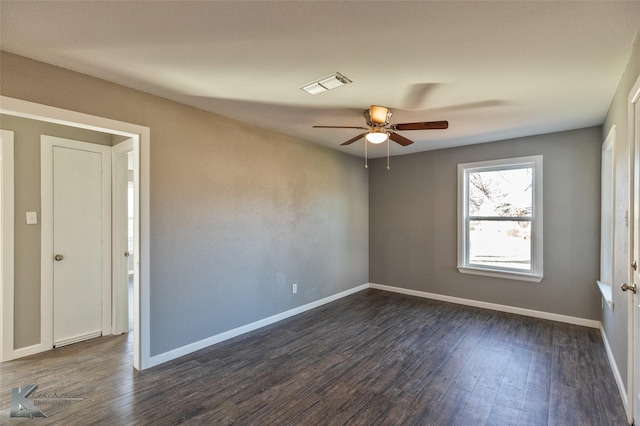 spare room featuring dark wood-type flooring and ceiling fan