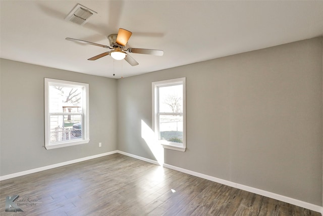 empty room with dark hardwood / wood-style flooring and ceiling fan