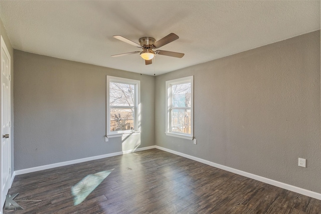 spare room with dark hardwood / wood-style flooring and ceiling fan