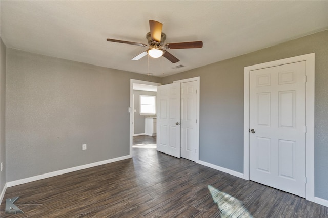 unfurnished bedroom with ceiling fan and dark hardwood / wood-style floors