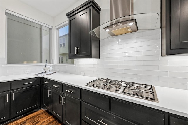 kitchen with stainless steel gas stovetop, dark hardwood / wood-style floors, ventilation hood, and decorative backsplash