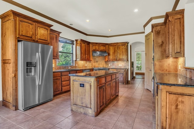 kitchen with tile patterned floors, a center island, stainless steel fridge with ice dispenser, and dark stone counters