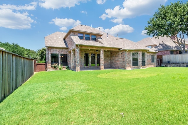 rear view of property with a yard