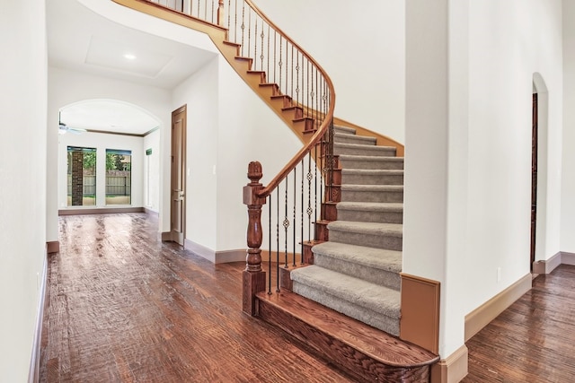 stairs with wood-type flooring and ceiling fan