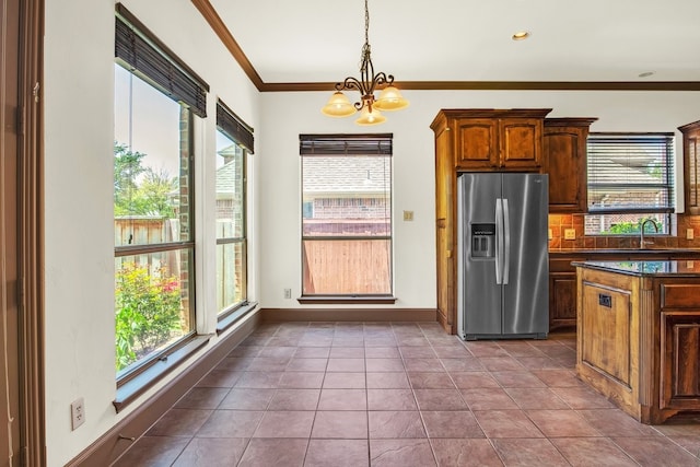 kitchen with crown molding, a wealth of natural light, stainless steel fridge, and tile patterned floors