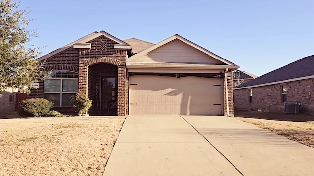 view of front of house with a garage and cooling unit